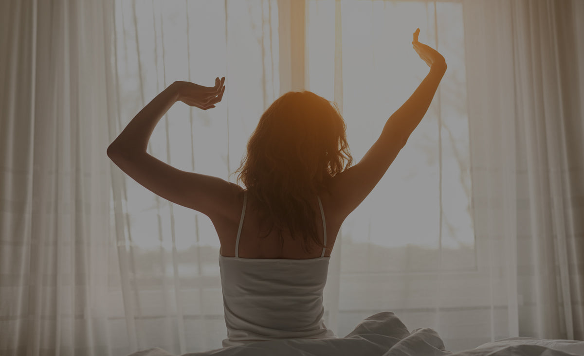 Stretching in bed at sunrise_dark